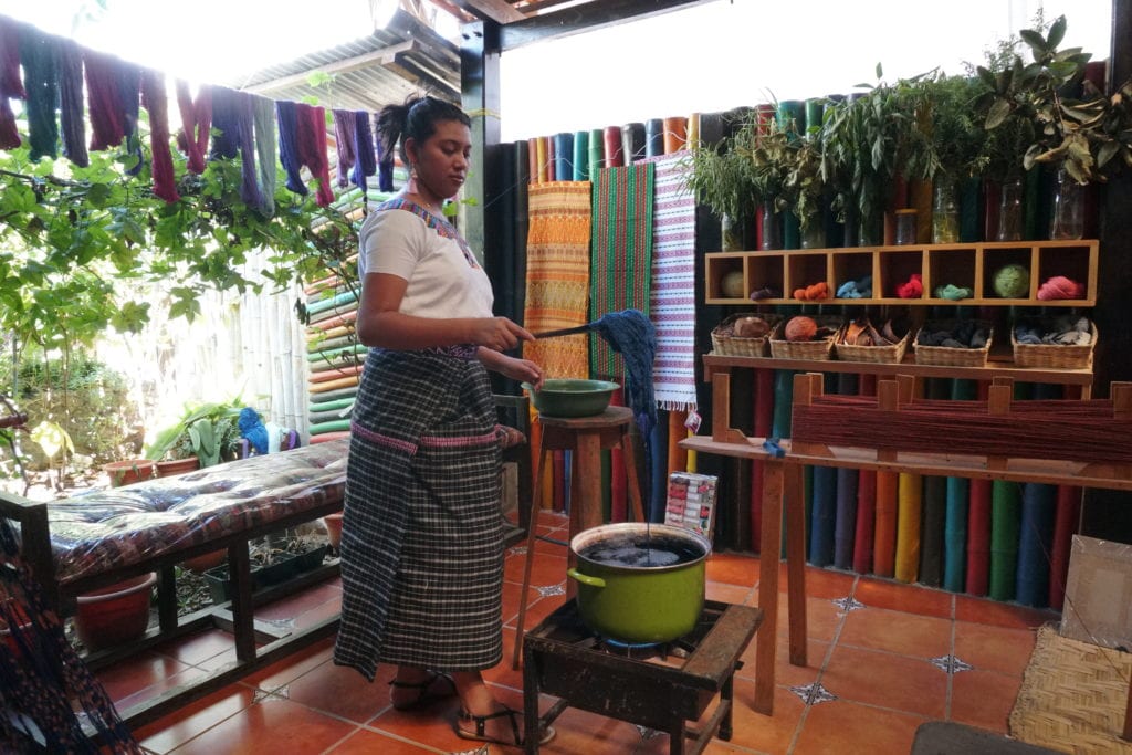 Lady in Mayan dress demonstrating dyeing yarn