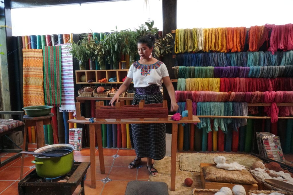 Lady in Mayan dress demonstrating ready to dye yarn