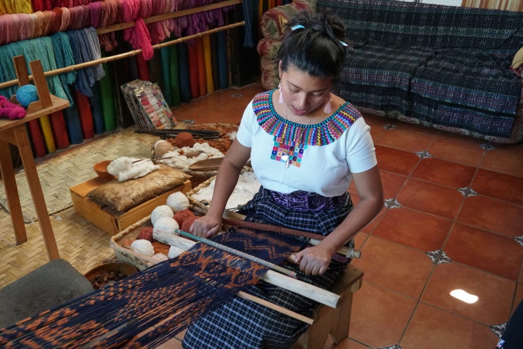 Lady in Mayan dress demonstrating making fabrics