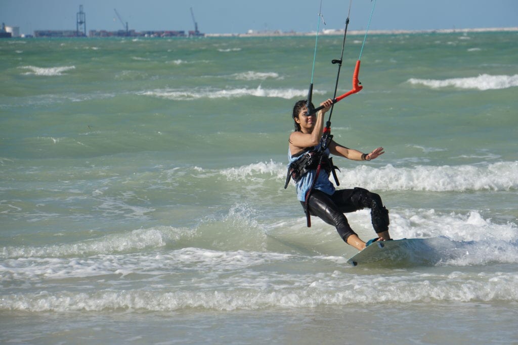 Girl kite surfing riding surf