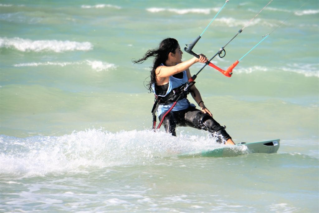 Girl kite surfing riding surf hair in wind