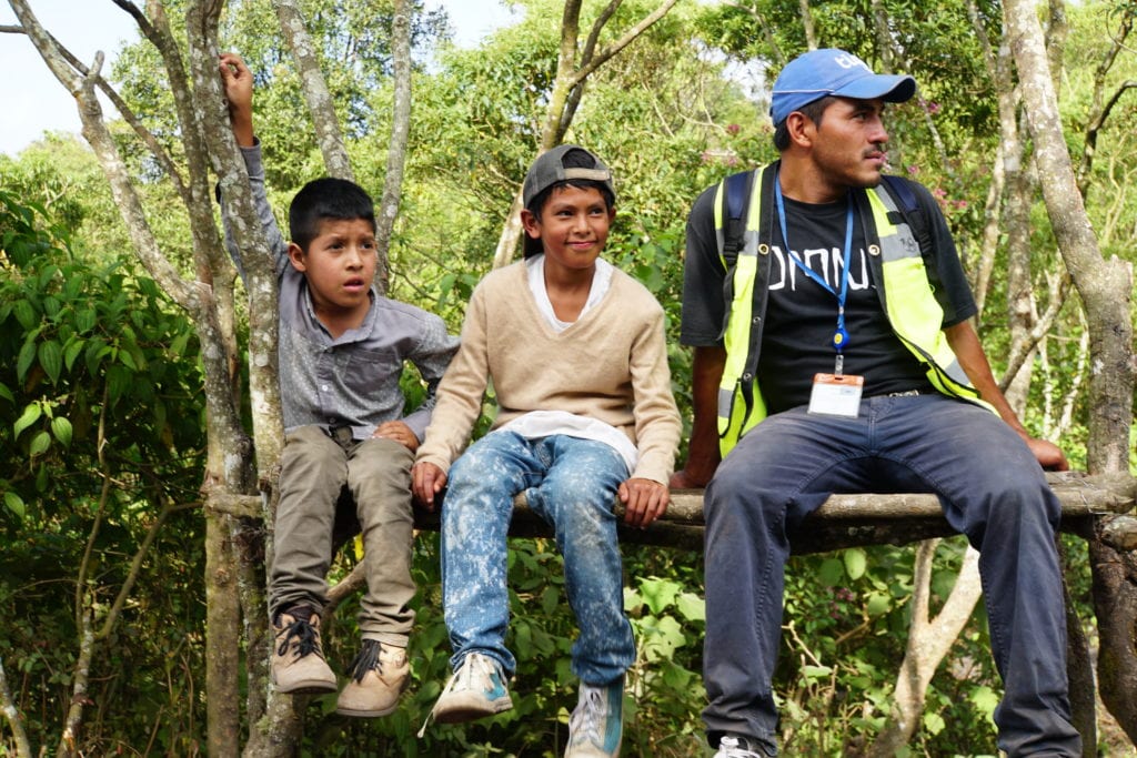 3 people sitting on bench at Pacaya volcano