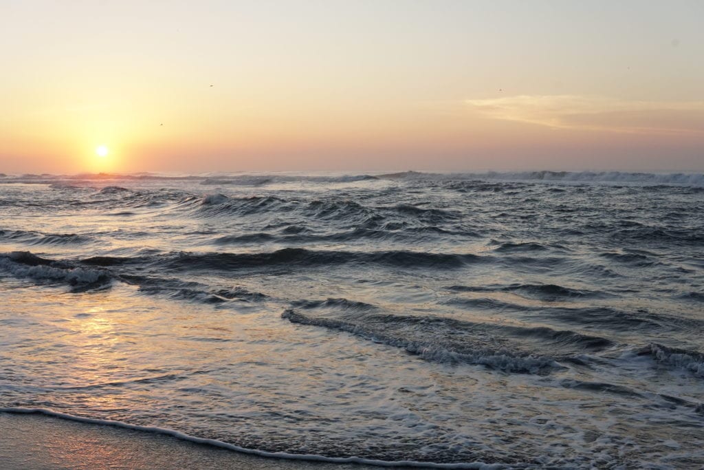 Sun setting viewed from beach Pacific Ocean