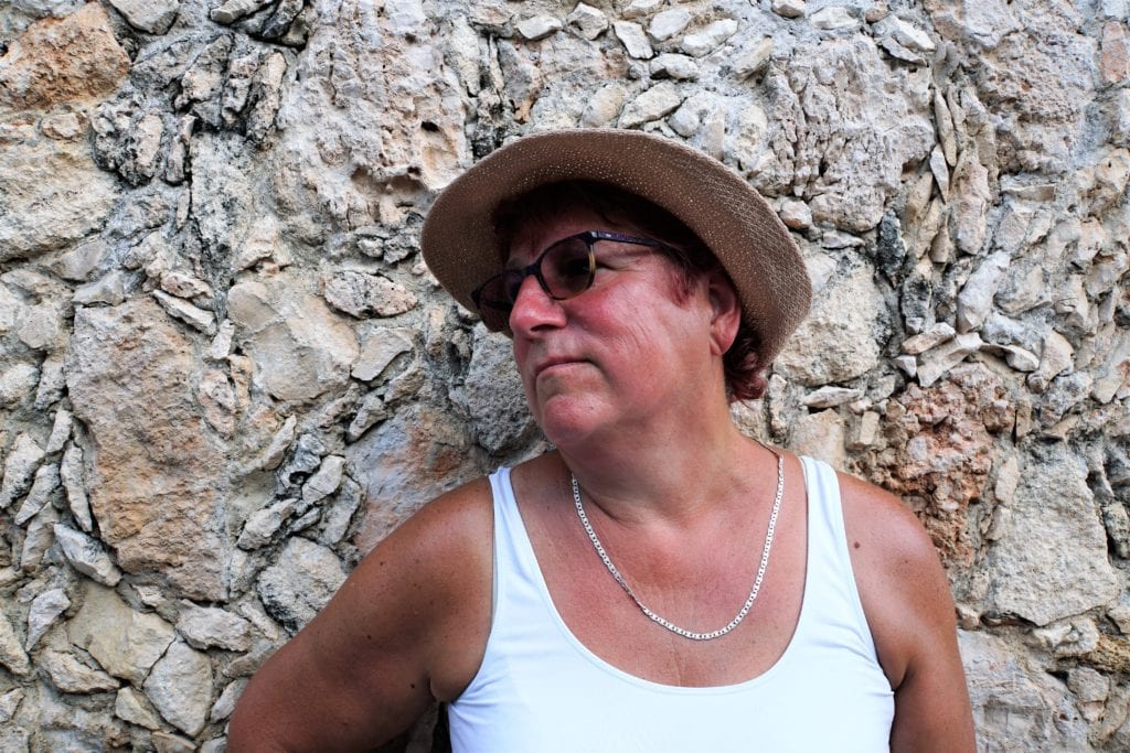 Portrait of Cindy looking to the side in front of stone wall