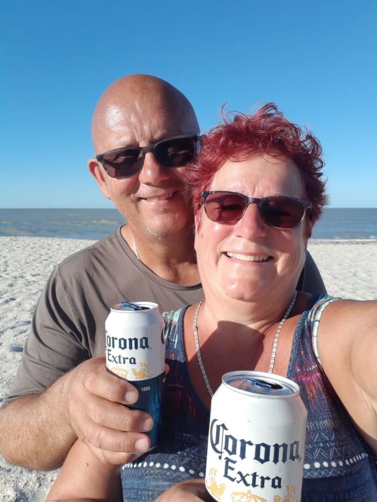 Cindy & I sitting on beach enjoying a couple of beer