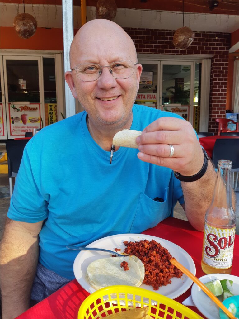 Greg in Cancun enjoying lunch with a cerveza